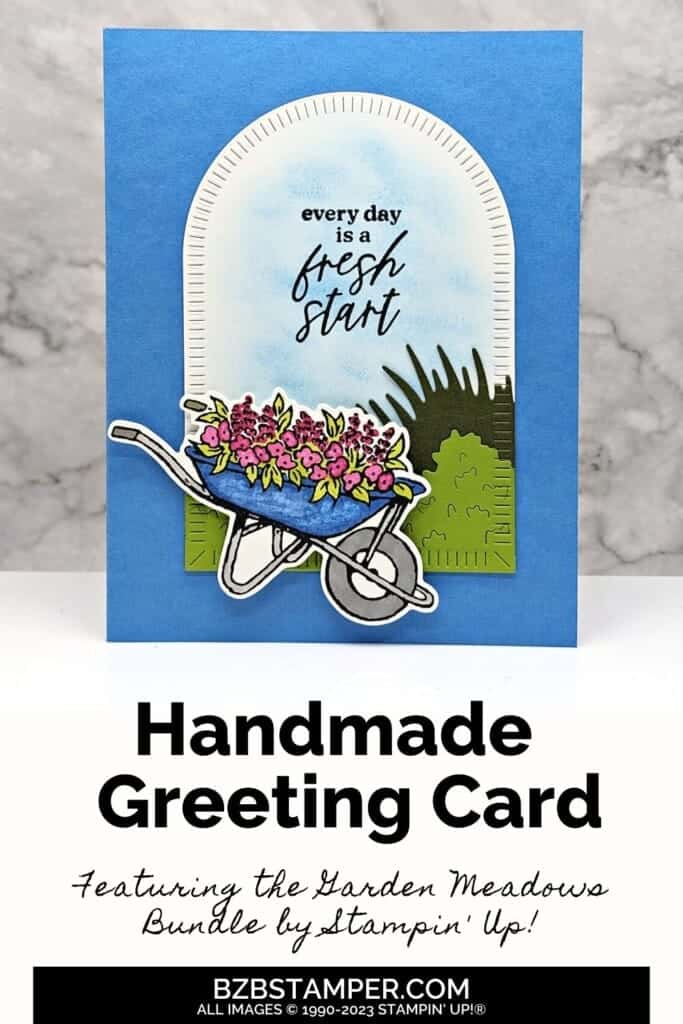 Garden Meadow All-Occasion Handmade Card 5 Handmade card in blues, greens and pinks featuring a wheelbarrow with flowers underneath an arch with sentiment "every day is a fresh start."
