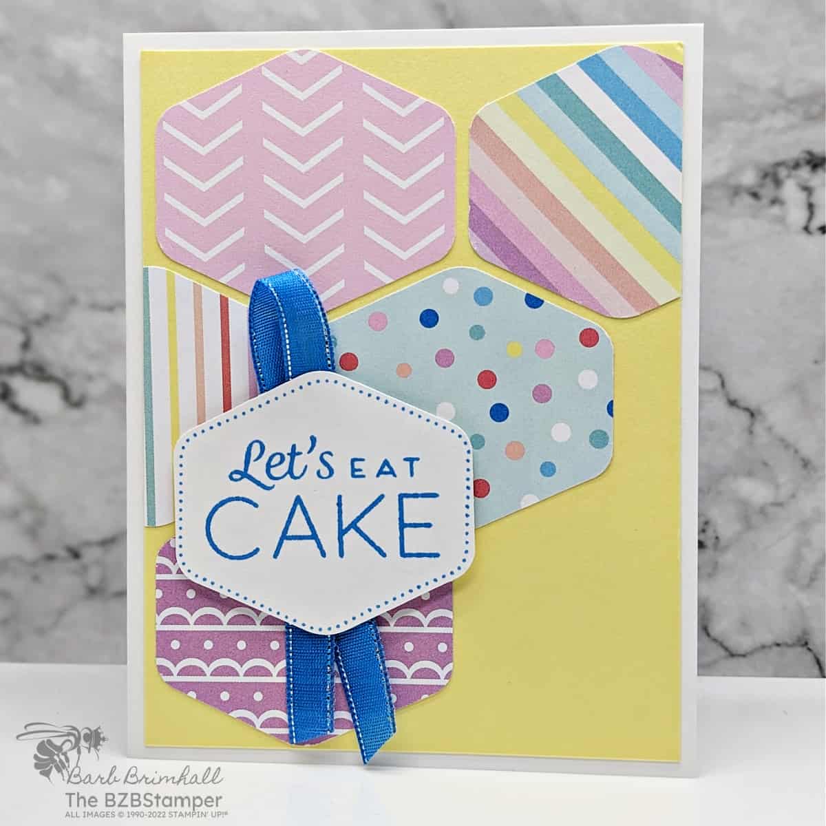 Heartfelt Hexagon Birthday Card 1 Heartfelt Hexagon Birthday Card featuring hexganon shapes punched from pretty paper in a variety of colors including blue and yellow. Sentiment is "let's eat cake".
