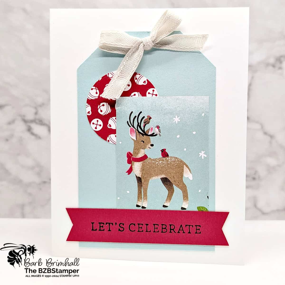 5 Minute Celebrate Card using Holiday Card Sketch 7 featuring red and blue, with a reindeer as the focal point and some pretty paper with bells. Sentiment is "Let's Celebrate".