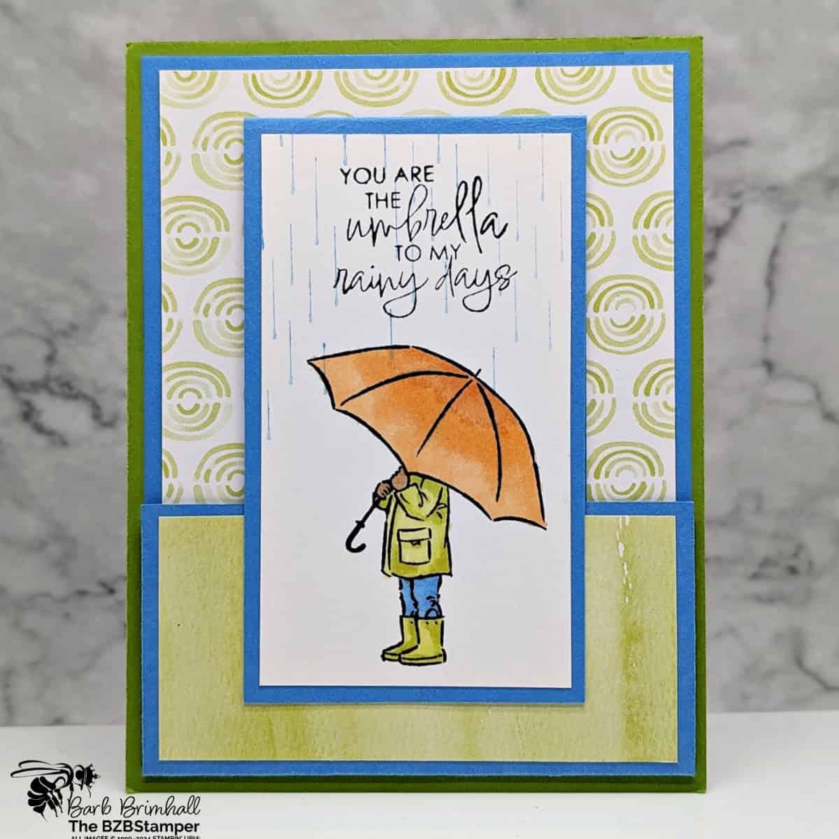 Fun Fold with the Umbrella Days Stamp Set 1 Fun Fold with the Umbrella Days Stamp Set in blues, greens and oranges, with someone holding an umbrella and a "you are the umbrella to my rainy days" sentiment.