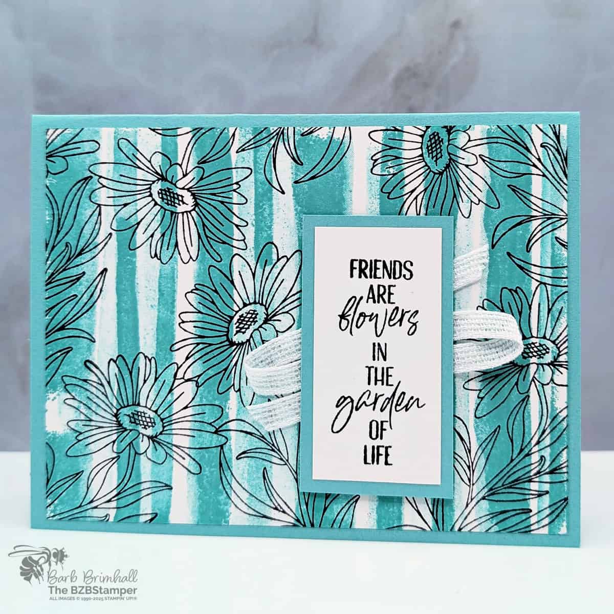 Friends Card using the You Are Remarkable Stamp Set in blues and black with stripes and daisy flowers, white ribbon and a "friends are flowers in the garden of life" sentiment.
